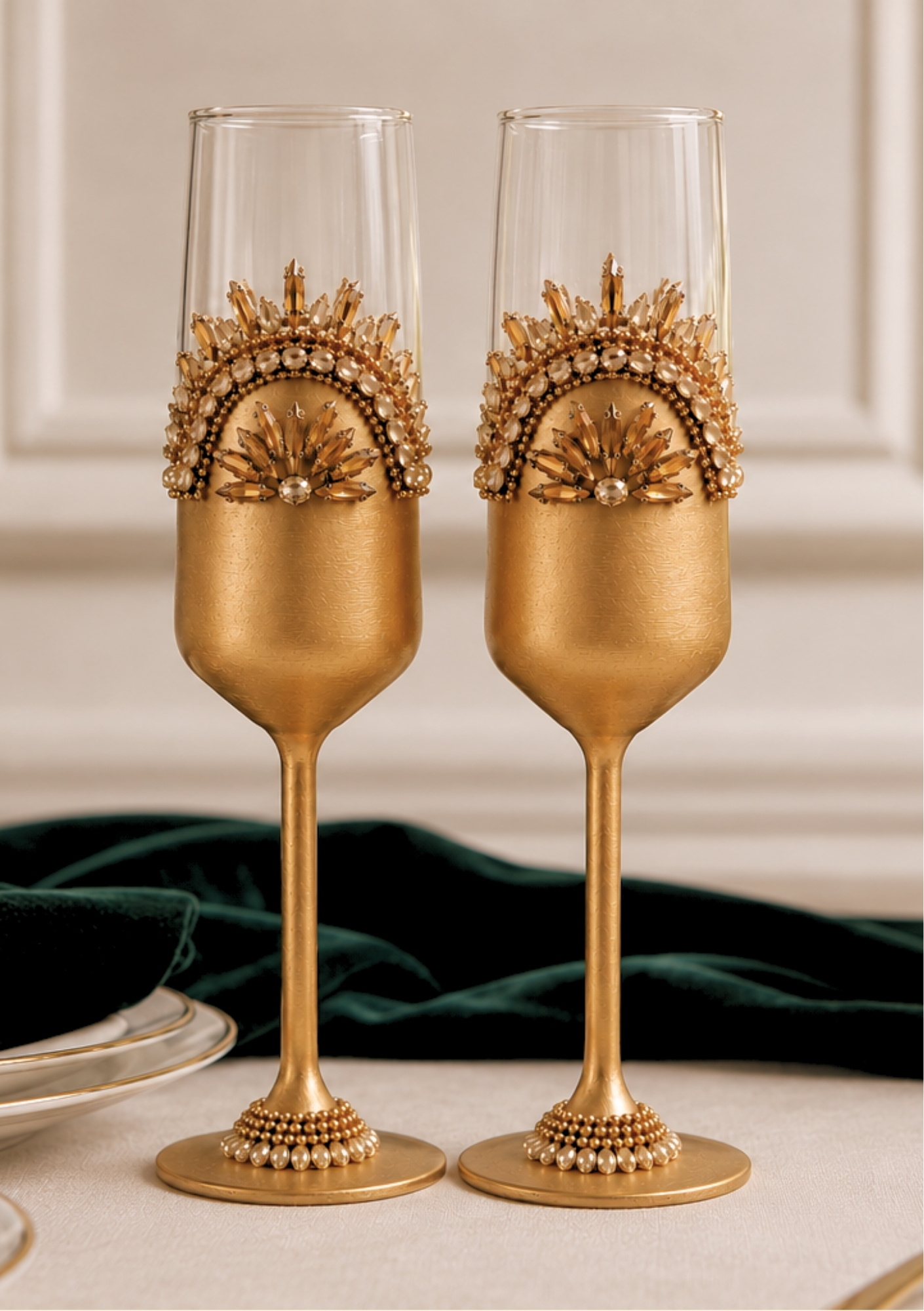 Pair of Zahra Razvi Helene luxury champagne flutes, hand-painted gold with intricate crystal and gold embellishments.
